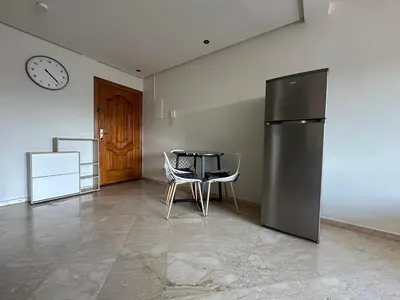 a dining room with a table and a refrigerator at Appartement chic et cosy en plein centre de Gueliz in Marrakech