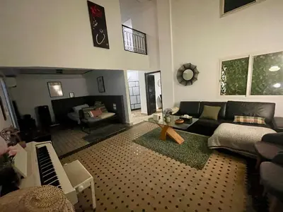 a living room with a couch and a piano at Au Riad Des Sultans - Marrakech in Marrakech