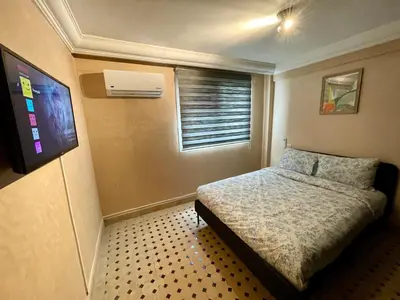 a small bedroom with a bed and a television at Au Riad Des Sultans - Marrakech in Marrakech
