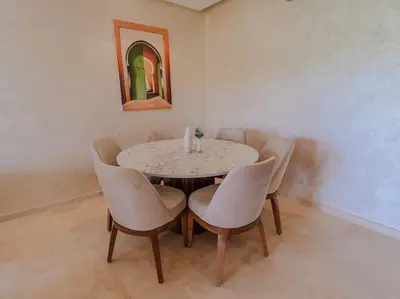 a dining room with a table and chairs at Magnifique appartement 3 chambres à Prestigia in Marrakech