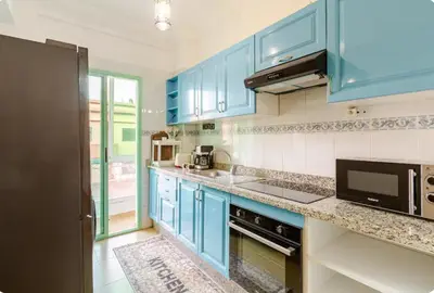 a kitchen with blue cabinets and a microwave at Charming Two-Bedroom Apartment in Marrakesh Gueliz in Marrakech