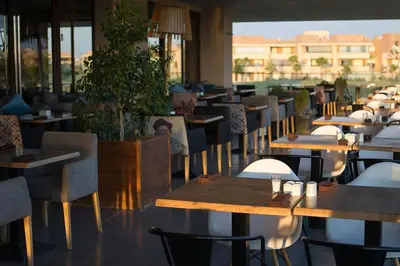a restaurant with wooden tables and chairs at Luxurious Apartment Marrakech with Pool, Golf, Private Garden in Marrakech