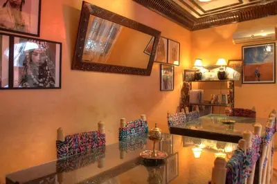 a dining room with a glass table and chairs at Riad ELIZZI in Marrakech