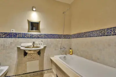 a bathroom with a sink and a bath tub and a sink at Oasis de l'Atlas by Golf Resort in Marrakech