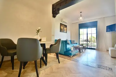 a living room with a table and chairs at Oasis de l'Atlas by Golf Resort in Marrakech