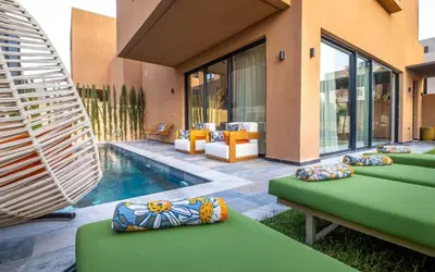 a house with a swimming pool and some pillows at Villa ZINA I Luxe I Piscine chauffée I Wifi I Proche centre Ville in Marrakech