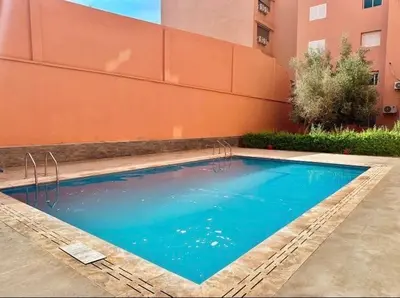 a large blue swimming pool next to a building at appartement moderne,gueliz in Marrakech