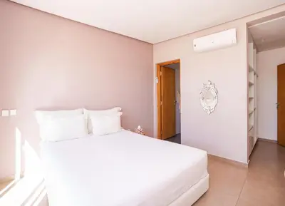 a bedroom with a white bed with white pillows at le petit dar alwalidine in Marrakech