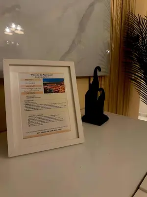 a framed picture on a table next to a bird at Elegant Apartment with Pool, Clim & Wi-Fi - 7min Gueliz in Marrakech