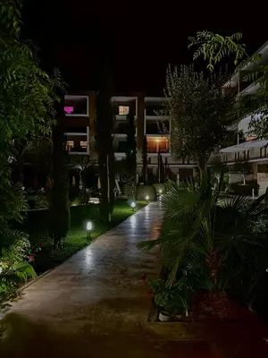 a walkway at night with lights in a building at Elegant Apartment with Pool, Clim & Wi-Fi - 7min Gueliz in Marrakech