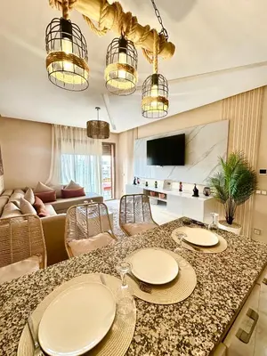 a living room with a table with chairs and a couch at Elegant Apartment with Pool, Clim & Wi-Fi - 7min Gueliz in Marrakech