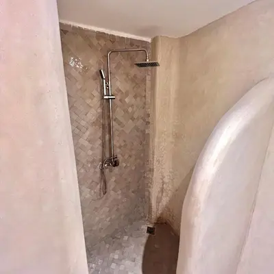 a shower in the corner of a bathroom at Riad Ouatine in Marrakech