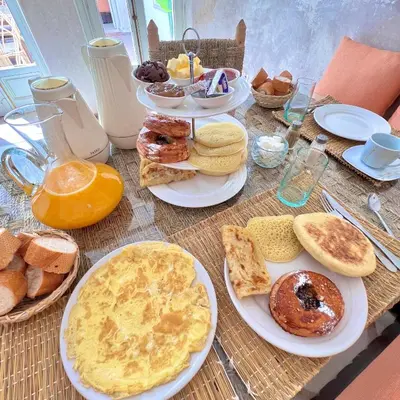 a table with plates of breakfast food on it at Riad Ouatine in Marrakech