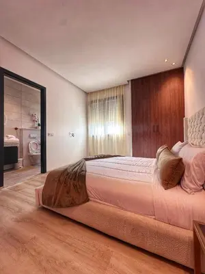 a bedroom with a large bed and a bathroom at villa 105 golf noria piscine chauffée in Marrakech