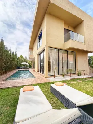 a house with a swimming pool in front of it at villa 105 golf noria piscine chauffée in Marrakech