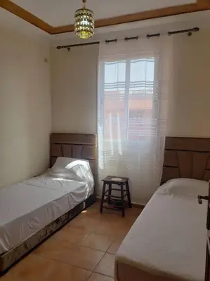 a bedroom with two beds and a window with a table at Marrakesh 3 Bedroom Oasis in Marrakech