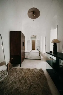 a large bedroom with a bed and a large chandelier at Riad KRÈME in Marrakech