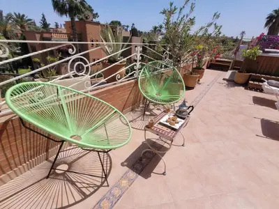 two green chairs sitting on top of a balcony at MELBARI Cosy-Appart in Marrakech
