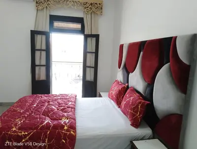a bedroom with a bed with a red blanket and a window at Medina-in auberge in Marrakech