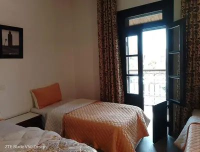 a room with a bed and a window with a chair at Medina-in auberge in Marrakech