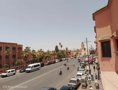 a busy street in a city with cars and people at Medina-in auberge in Marrakech