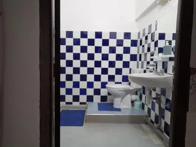a bathroom with a checkered floor and a toilet and sink at Appart 3 mins from Jamaâ el fana in Marrakech