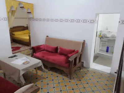 a living room with a red chair and a table at Appart 3 mins from Jamaâ el fana in Marrakech