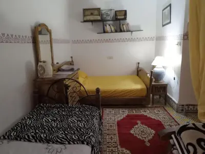 a bedroom with a bed and a chair and a mirror at Appart 3 mins from Jamaâ el fana in Marrakech