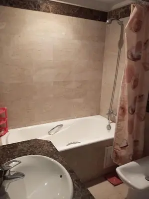 a bathroom with a tub and a sink and a toilet at Le Fairouz Appartement Haut Standing centre ville Piscine in Marrakech