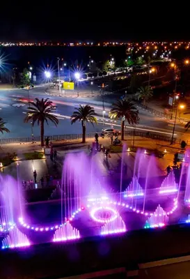 a fountain with purple lights in a city at night at Logement de luxe avec piscine, hivernage in Marrakech