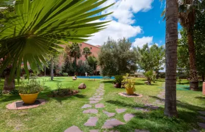 a park with palm trees and a pathway at Logement de luxe avec piscine, hivernage in Marrakech