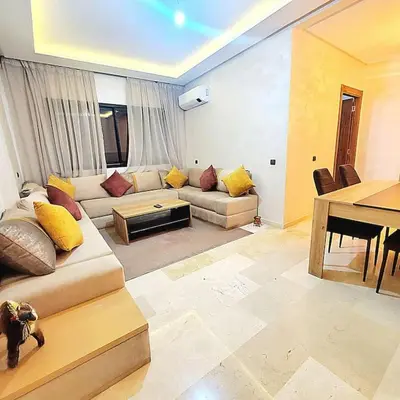 a living room with a couch and a table at Appartement haut standing plein centre gare in Marrakech
