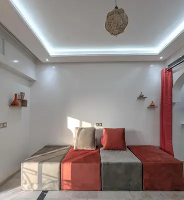 a bedroom with a bed with colorful pillows on it at Apartement Panoramic View Majorelle Garden with Pool in Marrakech