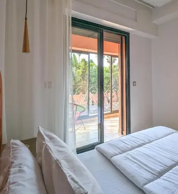 a bedroom with two beds and a sliding glass door at Apartement Panoramic View Majorelle Garden with Pool in Marrakech