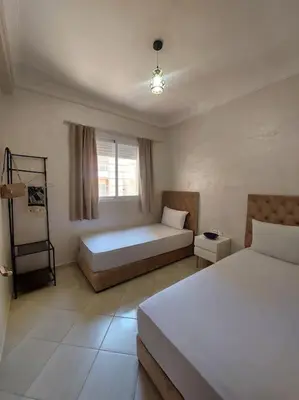 a bedroom with two beds and a window at Modern family apartment near airport in Marrakech