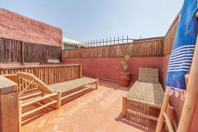 a patio with two chairs and a table and a cactus at Riad Macan Exclusive and Trendy Chich Breakfast incl in Marrakech