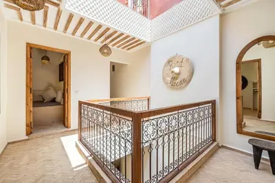 a hallway with a wooden staircase and a mirror at Riad Macan Exclusive and Trendy Chich Breakfast incl in Marrakech