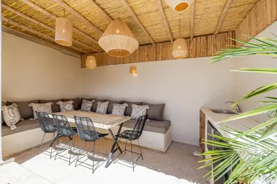 a room with a table and chairs and a couch at Riad Zatiah Exclusive and chic breakfast incl in Marrakech