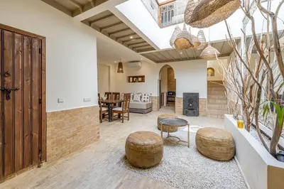 an open living room with a table and chairs at Riad Zatiah Exclusive and chic breakfast incl in Marrakech