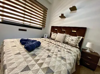a bedroom with a large bed with blue pillows at Appartement de luxe en face la gare à gueliz marrakech in Marrakech