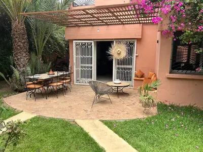 a patio with a table and chairs in a yard at Magnifique villa 5 chambres à Gueliz au Centre de Marrakech in Marrakech