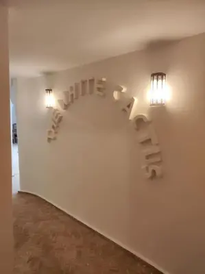 a white wall with a sign that says the wordulum at Riad White Cactus in Marrakech