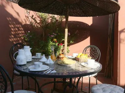 a table with an umbrella and food on it at Riad El Bellar in Marrakech