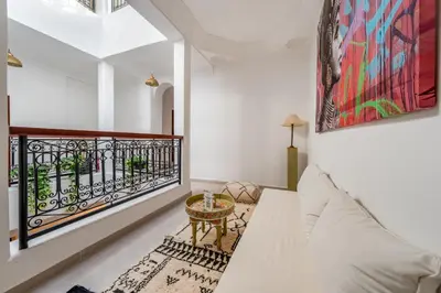 a room with a balcony with a couch and a table at Riad privatisé terrasses et matin gourmand in Marrakech