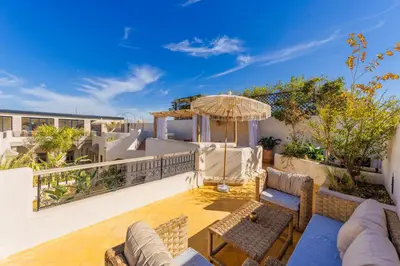 a patio with furniture and an umbrella on a balcony at Suites & Spa - Riad XO in Marrakech