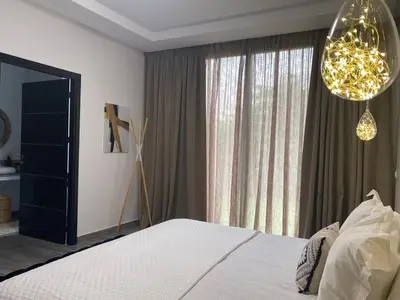 a bedroom with a bed and a large window at Domaine de Kali, villa 2 au calme, piscine privée in Marrakech