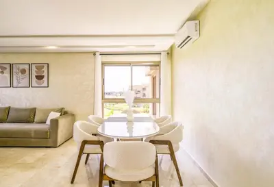 a living room with a table and chairs and a couch at Vue Montagnes, Golf et Piscine, Luxe à Marrakech in Marrakech