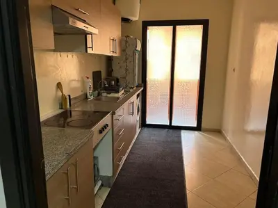 a kitchen with white cabinets and a large window at Cosy & Calm appartement in Marrakech