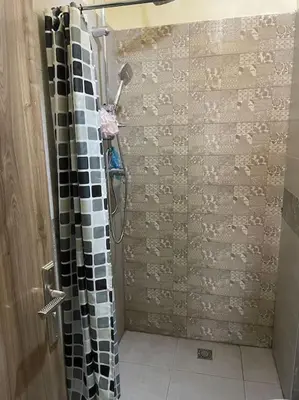 a shower with a black and white shower curtain in a bathroom at Le cœur de L'orient Marrakech in Marrakech