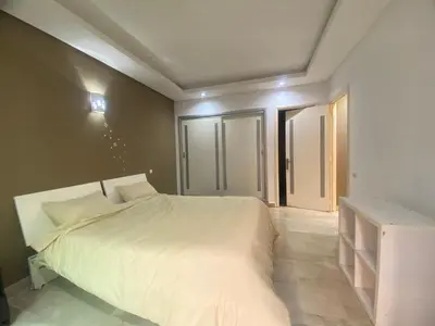 a bedroom with a white bed and some windows at new and modern apartment in Marrakech